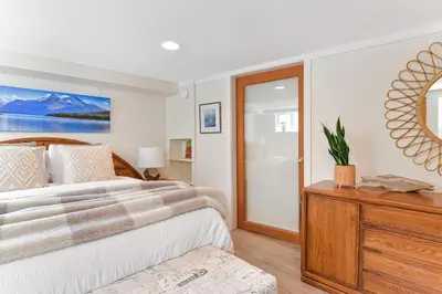 a bedroom with a large bed and a mirror at Gulf Island View Suite by EMR Vacation Rentals in Chemainus