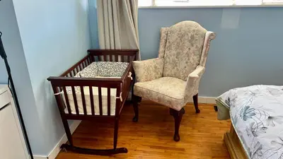 a bedroom with a chair and a table and a bed at Spacious home 15mins to Downtown in Vancouver