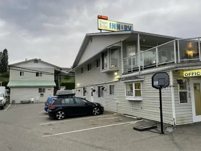 a car parked in a parking lot in front of a building at Fraser Bridge Inn in Quesnel