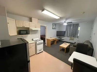 a kitchen and a living room with a couch and a table at Fraser Bridge Inn in Quesnel