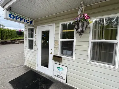 a building with a flower pot on the side of it at Fraser Bridge Inn in Quesnel