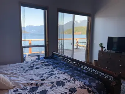 a bedroom with a bed and a view of the water at Earls Cove Orca View in Egmont