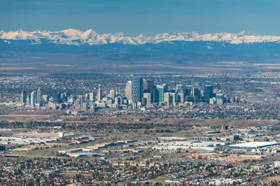an aerial view of a city with buildings and mountains at Divine Homes in Calgary