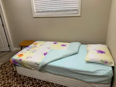 a bed in a bedroom with a flower patterned sheets at Divine Homes in Calgary