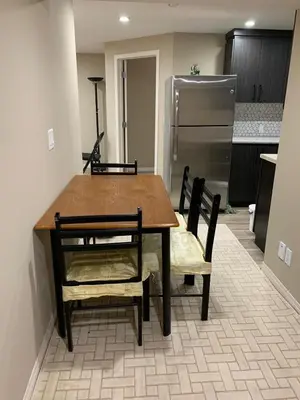 a kitchen with a table and chairs and a refrigerator at Divine Homes in Calgary