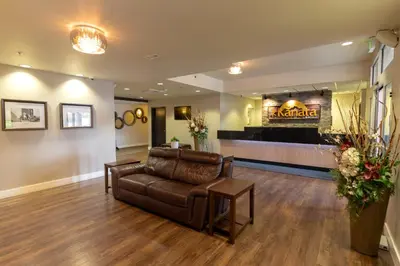 a lobby with a leather couch and a waiting room at Kanata Whitecourt in Whitecourt