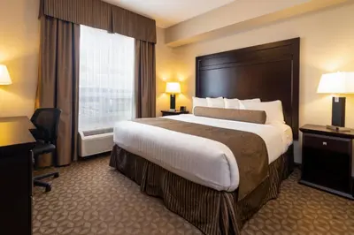 a hotel room with a large bed and a window at Kanata Whitecourt in Whitecourt