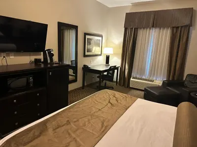 a hotel room with a bed and a desk at Kanata Whitecourt in Whitecourt