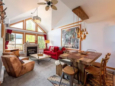 a living room with a table and a red couch at Glacier Lodge Steps to Trails and Nature in Whistler