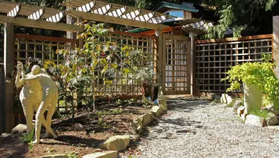 a garden with a fence and a statue of a horse at Thistle Dew Cottage in Ganges
