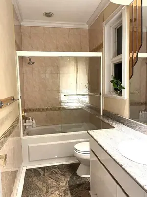 a bathroom with a tub and a toilet and a sink at Van Nest near YVR UBC Downtown in Vancouver