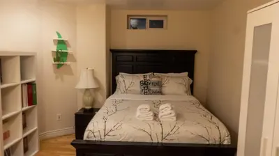 a bedroom with a bed with two towels on it at Van Nest near YVR UBC Downtown in Vancouver