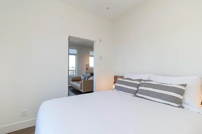a bedroom with a white bed with two pillows at Be Close To Chinatown When You Are In The Ironwork Building in Victoria