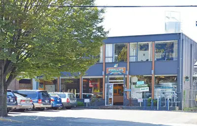 a store front with cars parked in a parking lot at Be Close To Chinatown When You Are In The Ironwork Building in Victoria