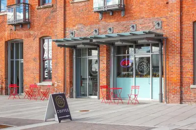 a brick building with red chairs and a sign in front of it at Be Close To Chinatown When You Are In The Ironwork Building in Victoria