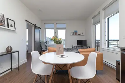 a living room with a white table and a couch at Be Close To Chinatown When You Are In The Ironwork Building in Victoria