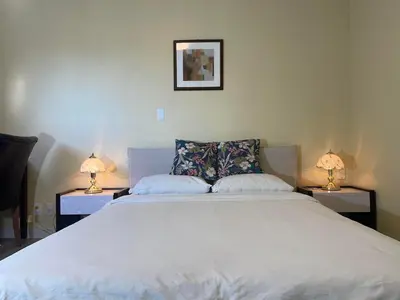 a bedroom with a large white bed with two lamps at New Master room & private washroom 203 in Richmond