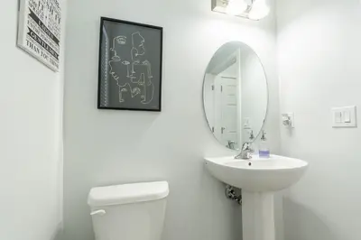 a white bathroom with a sink and a mirror at 3bedroom Stylish Getaway by the Park with 2-Car Garage in Calgary