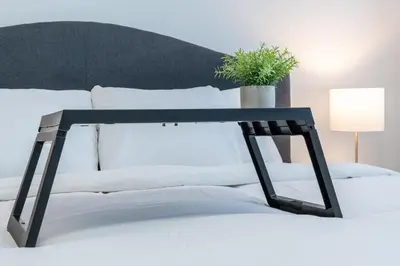 a black and white bed with a plant on it at 3bedroom Stylish Getaway by the Park with 2-Car Garage in Calgary