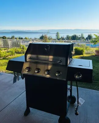 a black barbecue grill sitting on top of a patio at Four Seasons Private Villa in Powell River