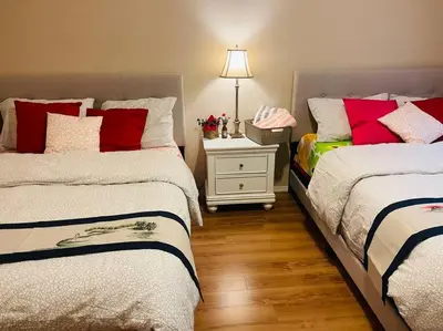 a bedroom with two beds and a table with a lamp at Four Seasons Private Villa in Powell River