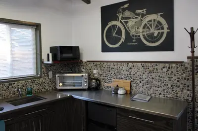 a kitchen with a sink and a motorcycle on the wall at Private Bright Modern Studio! Queen bed ! in Victoria