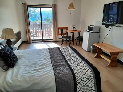 a bedroom with a bed and a table and a television at Alpen Motel in Radium Hot Springs