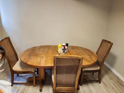 a dining room table with chairs and a wooden table at Economical Homestay hostel in Burnaby