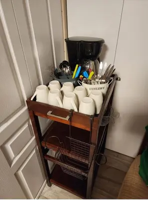 a shelf with cups and utensils on it at Economical Homestay hostel in Burnaby