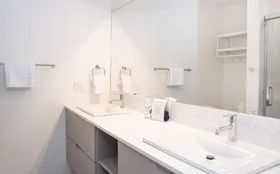 a white bathroom with two sinks and a mirror at Cabot Views by Revelstoke Vacations in Revelstoke