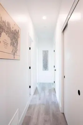 an empty hallway with white walls and a painting on the wall at Stoke House by Revelstoke Vacations in Revelstoke