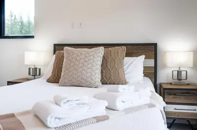 a bedroom with a white bed with towels on it at Stoke House by Revelstoke Vacations in Revelstoke