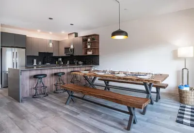 a kitchen with a wooden table and a bench at Stoke House by Revelstoke Vacations in Revelstoke