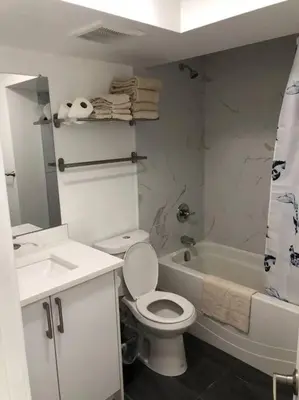 a bathroom with a toilet and a sink and a tub at Unit #201 Cozy Mountain View 1BR in DT in Canmore