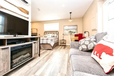a living room with a couch and a flat screen tv at RainCoast Retreat at Shawnigan Lake! in Shawnigan Lake