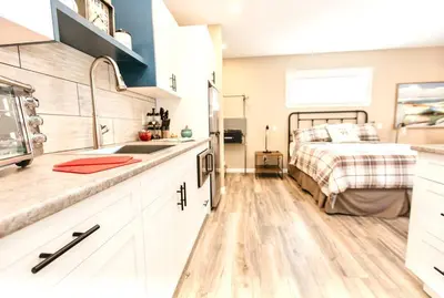 a kitchen with a sink and a bed in a room at RainCoast Retreat at Shawnigan Lake! in Shawnigan Lake