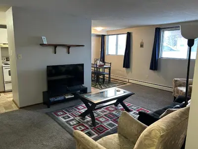 a living room with a tv and a coffee table at One Bedroom Main floor Apartment in Camrose