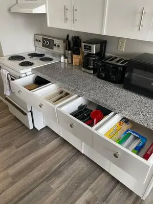 a kitchen with a counter with white drawers at Exquisite 2 Bedroom Apartment in Camrose