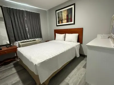 a bedroom with a large bed and a window at RAMSHORN MOTEL in Lumby