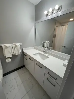 a bathroom with a sink and a large mirror at RAMSHORN MOTEL in Lumby