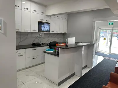a kitchen with white cabinets and a counter top at RAMSHORN MOTEL in Lumby