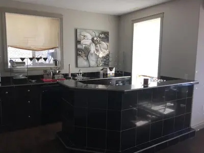 a black kitchen with a sink and a window at Private Walkout Suite with a View in Calgary