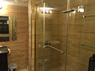 a shower with a glass door in a bathroom at Private Walkout Suite with a View in Calgary