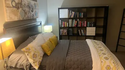 a bedroom with a bed and a book shelf with books at Private Walkout Suite with a View in Calgary
