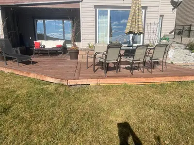 a wooden deck with chairs and a table on a house at Private Walkout Suite with a View in Calgary