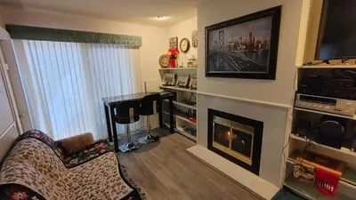 a living room with a fireplace and a tv at Beds By the Bridge in Kelowna