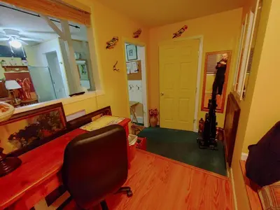 a room with a desk and a chair and a mirror at Beds By the Bridge in Kelowna