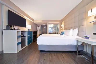 a hotel room with a large bed and a flat screen tv at Hotel BLU in Vancouver