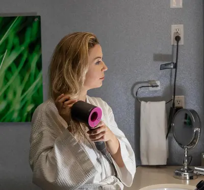 a woman sitting at a desk holding a hair dryer at Hotel BLU in Vancouver