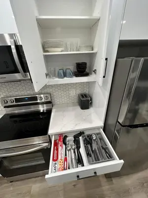 a kitchen with an open cabinet with utensils at 2 Bedroom 2 Washrooms Brand New Beautiful & Cozy Suite in Calgary